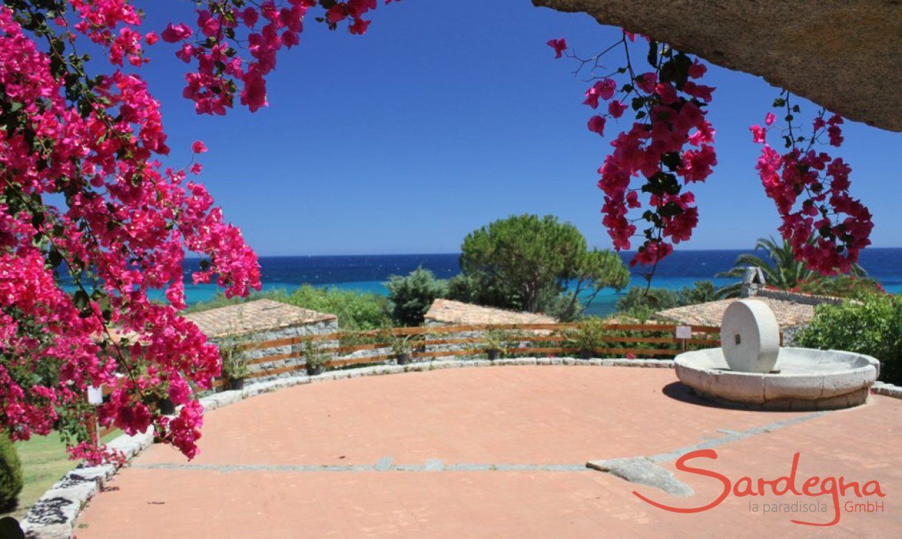 Sant Elmo square with bougainvillea, an old milestone in granite and sea view