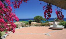 Sant Elmo square with bougainvillea, an old milestone in granite and sea view